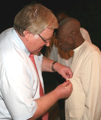Royal Danish Ambassador Bjarne Sorensen decorates Embassy Gardener Mzee Peter Namkwata with special medal from the Queen Margrethe II for his long time service at the embassy in Dar es Salaam yesterday. (Photo by Staff Photographer)